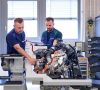 Zwei BMW-Mitarbeitende mit einem Brennstoffzellensystem