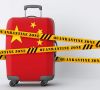 Koffer mit Chinaflagge, davor ein gelbes Absperrband mit "Quarantine Zone"