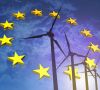 EU-Flagge mit Windrädern im Hintergrund.