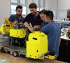 Vier Arbeiter montieren Roboter