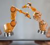 Zwei Roboter auf einem Tablet, das von einer Person gehalten wird