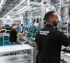 Mehrere Werker arbeiten in der Technologiefabrik Scharnhausen von Festo an Produkten in Losgröße 1 – sowohl vollautomatisiert als auch per Handmontage.