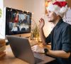 Arbeiten an Weihnachten: Mann sitzt mit Weihnachtsmütze vor Laptop