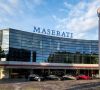 Das Maserati-Hauptsitz in Modena. Davor stehen unterschiedliche Maserati-Autos.
