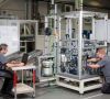 Mitarbeiter von ZBV-Automation bauen am Standort Troisdorf eine Maschine entsprechend dem
