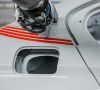 Eine Düse an einem Roboterarm lackiert rote Querstreifen auf ein Fahrzeugheck
