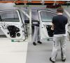 VW-Werker bei der Türmontage in der Autoproduktion