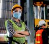 Eine Mitarbeiterin in der Industrie trägt am Arbeitsplatz eine Maske