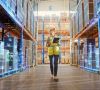 Eine Frau läuft durch ein digitalisiertes Logistiklager