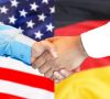 Händeschütteln vor den Flaggen der USA und Deutschlands