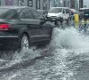 Auto passiert überflutete Straße