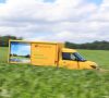 Elektroauto der deutschen post fährt durch ein Feld