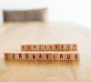 Auf einem Tisch stehen Scrabble-Buchstaben mit den Worten "Kurzarbeit" und "Coronavirus".