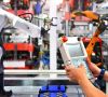 Ingenieur kontrolliert Roboterarm beim Verpackungsprozess von Lagern in der Automobilindustrie.