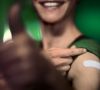 Frau mit Arm Pflaster Daumen hoch nach erfolgreicher Impfung Impfen