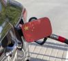 Ein Auto, das die chinesische Flagge auf dem Tankdeckel trägt, wird mit einer Zapfpistole betankt.