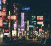 eine chinesische Straße bei Nacht mit leuchtenden Reklameschildern