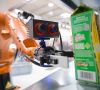 Sehender Roboter von Kuka bei der Palettierung von Milchtüten