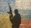 Flaggen von Russland und der Ukraine auf einer Mauer, davor Schatten eines Soldaten