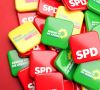 SPD, FDP und Grünen Sticker liegen auf einem Haufen.